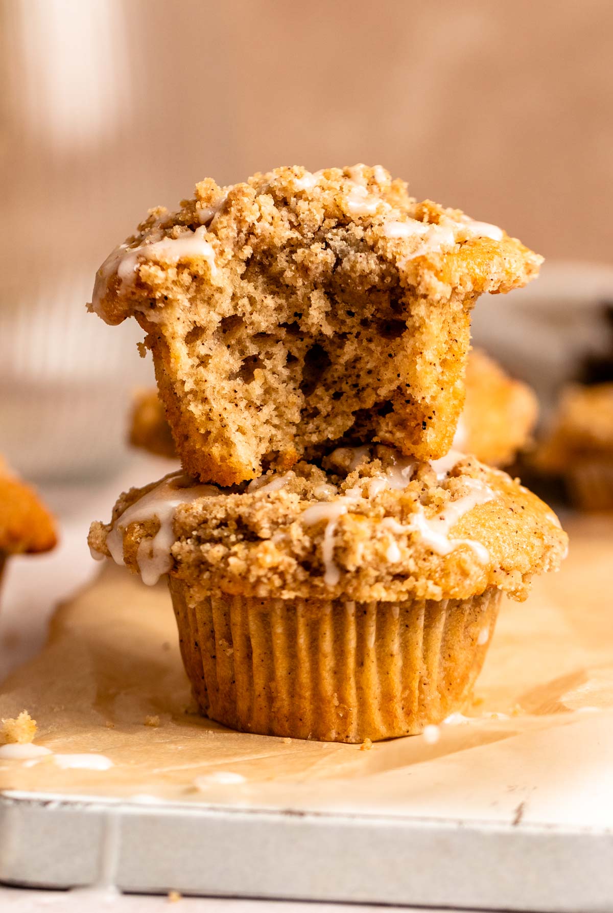 Two cinnamon streusel muffins with one missing a bite.