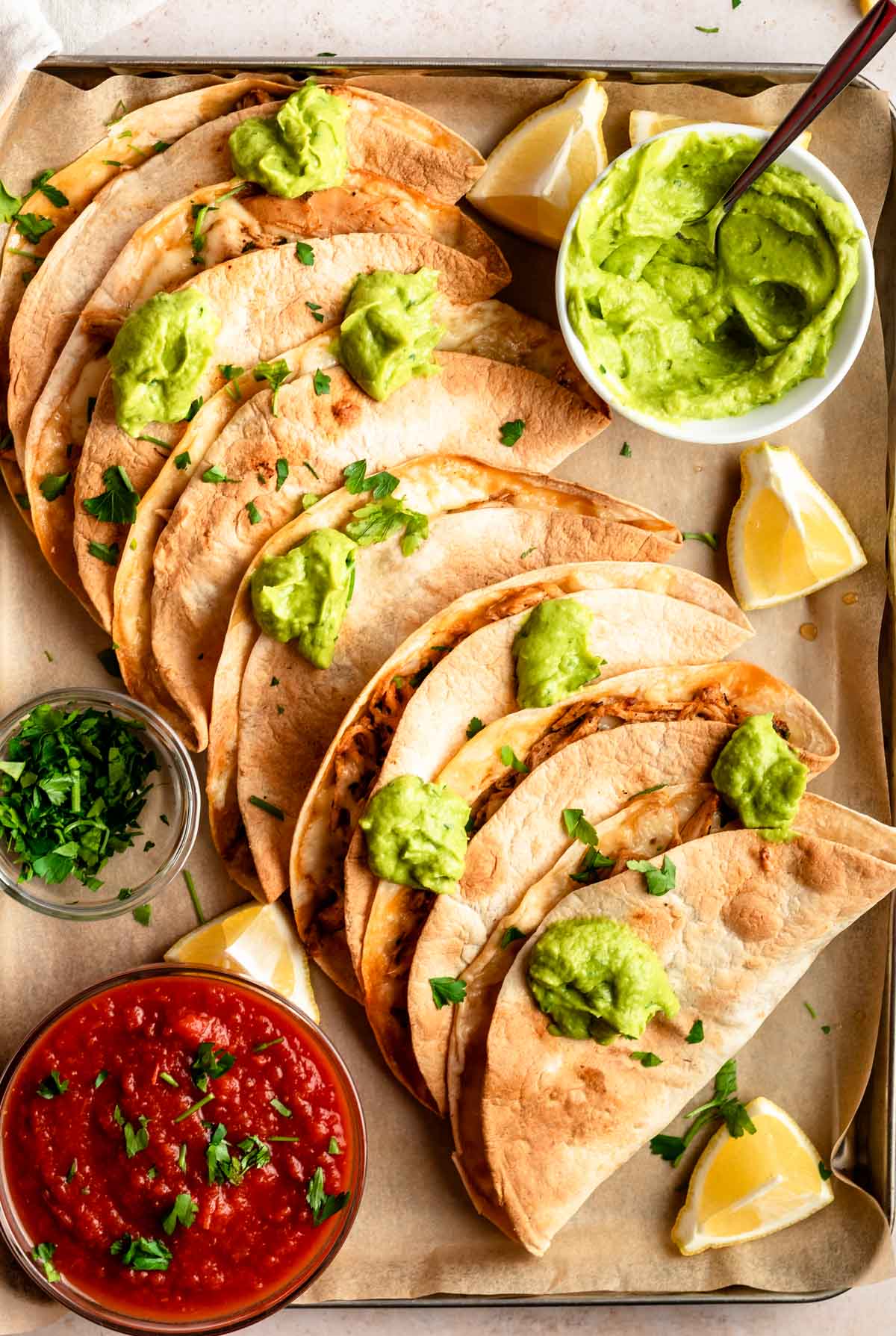 Top of baked chicken tacos with guacamole on top.