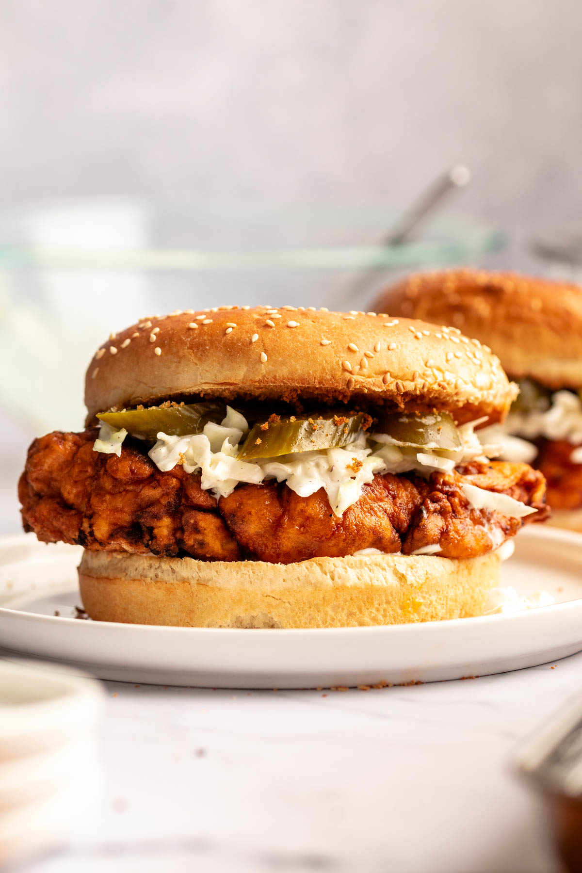 Nashville hot chicken sandwich on a white plate.