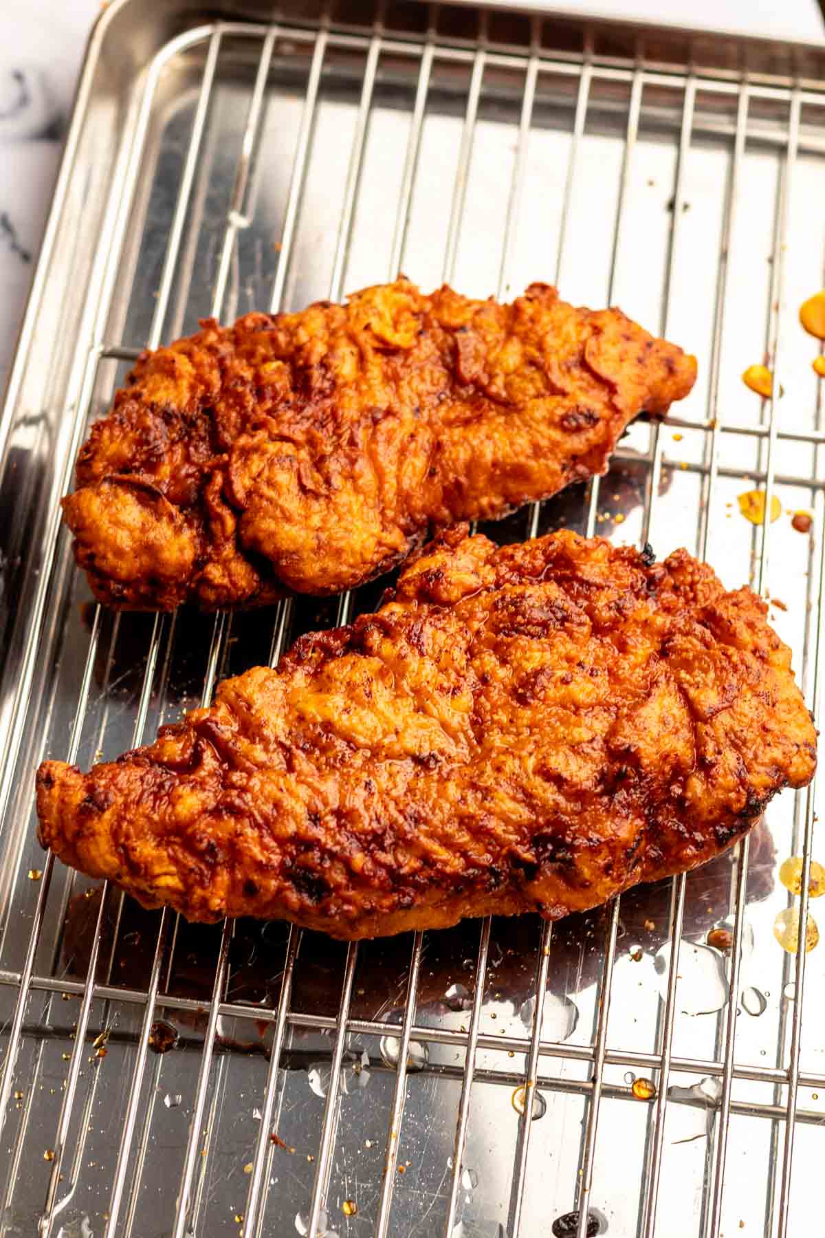 Fried Nashville hot chicken on a cooling rack.