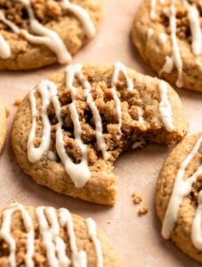 Coffee cake cookies with cream cheese glaze with the middle one with a bite missing.