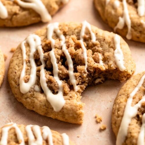 Coffee cake cookies with cream cheese glaze with the middle one with a bite missing.