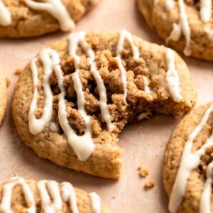 Coffee cake cookies with cream cheese glaze with the middle one with a bite missing.