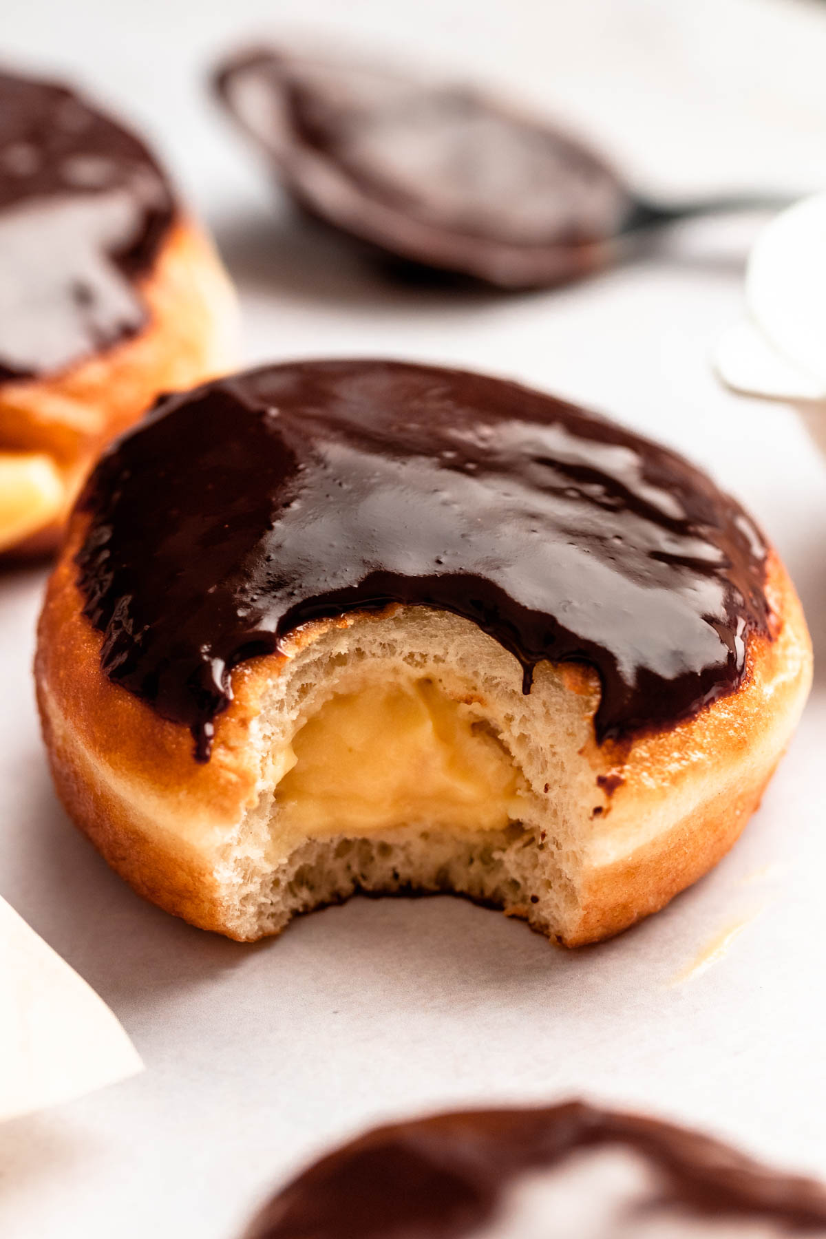 Single Boston cream donut with a bite missing.