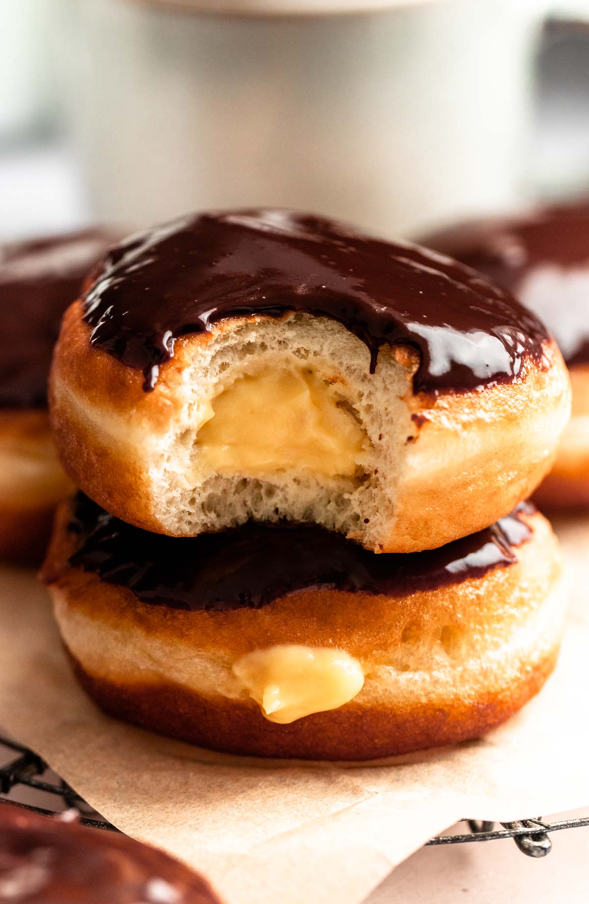 Stack of two custard donuts with the top one missing a bite.