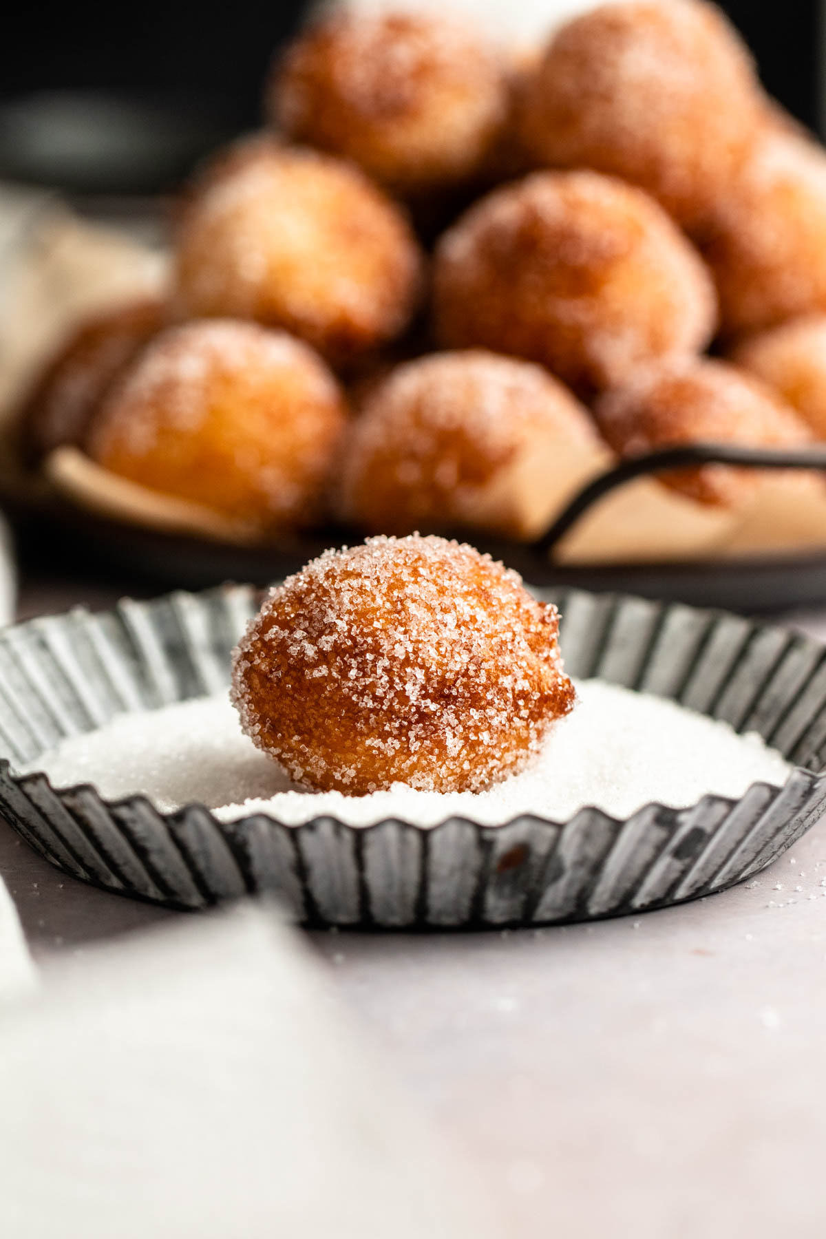 Donut hole in a plate with sugar.