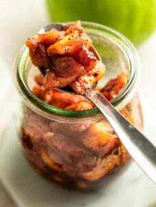 Apple compote in a jar with a spoon with the compote.