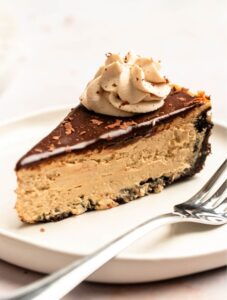 Slice of coffee cheesecake on a white plate.