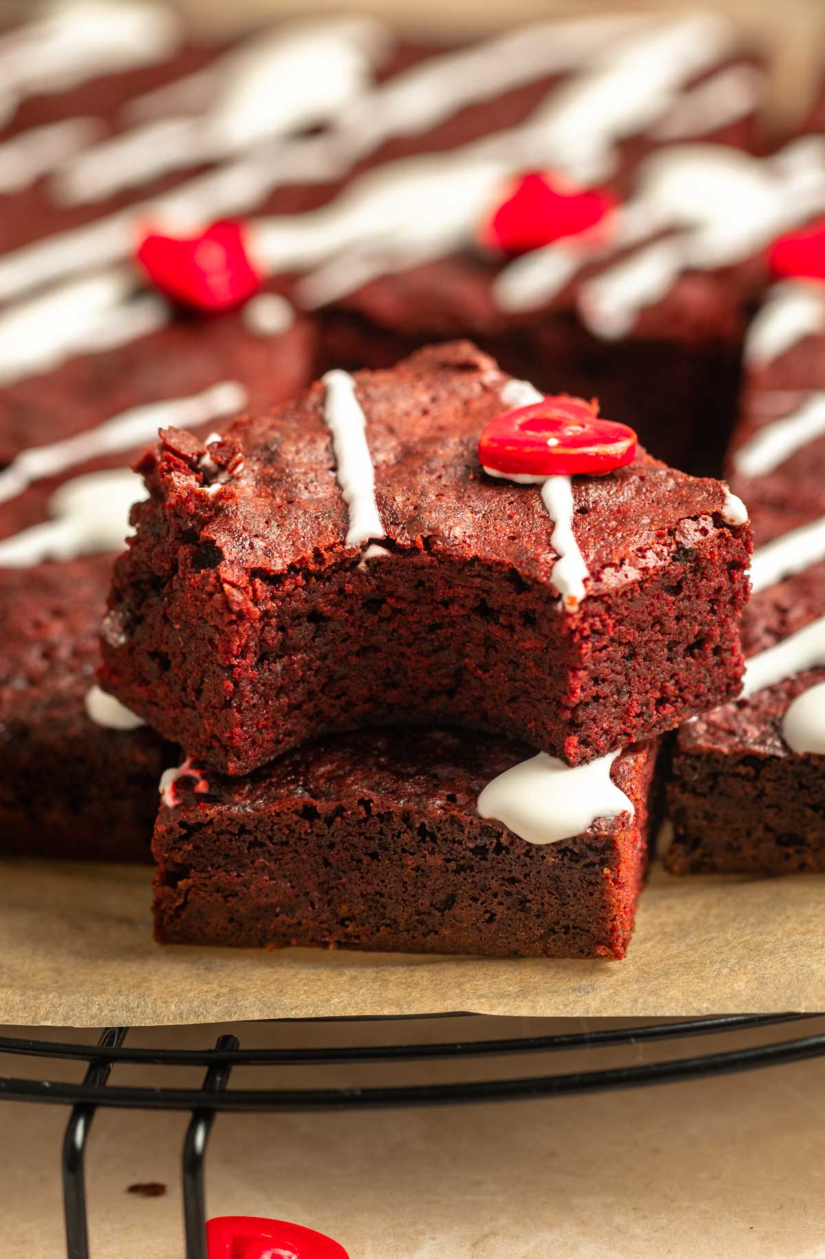 Two slices of red velvet brownies with the top one missing a bite.