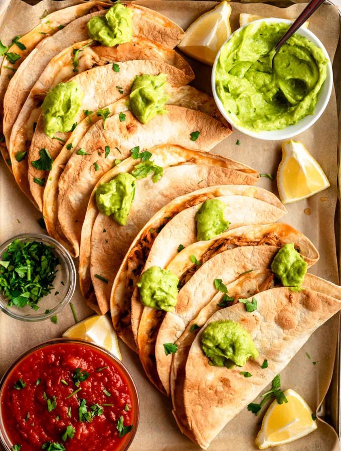 Top of baked chicken tacos with avocado sauce on top.