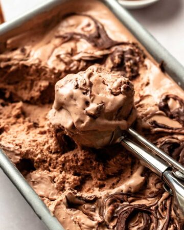 Close up shot of Nutella ice cream with an ice cream scoop in the pan.