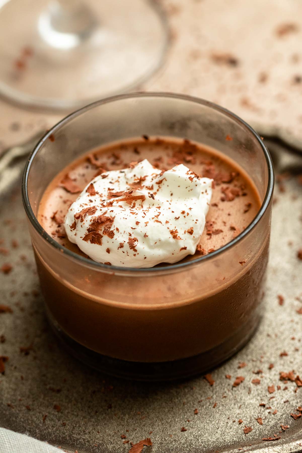 Chocolate Panna Cotta in a glass with whipped cream on top.