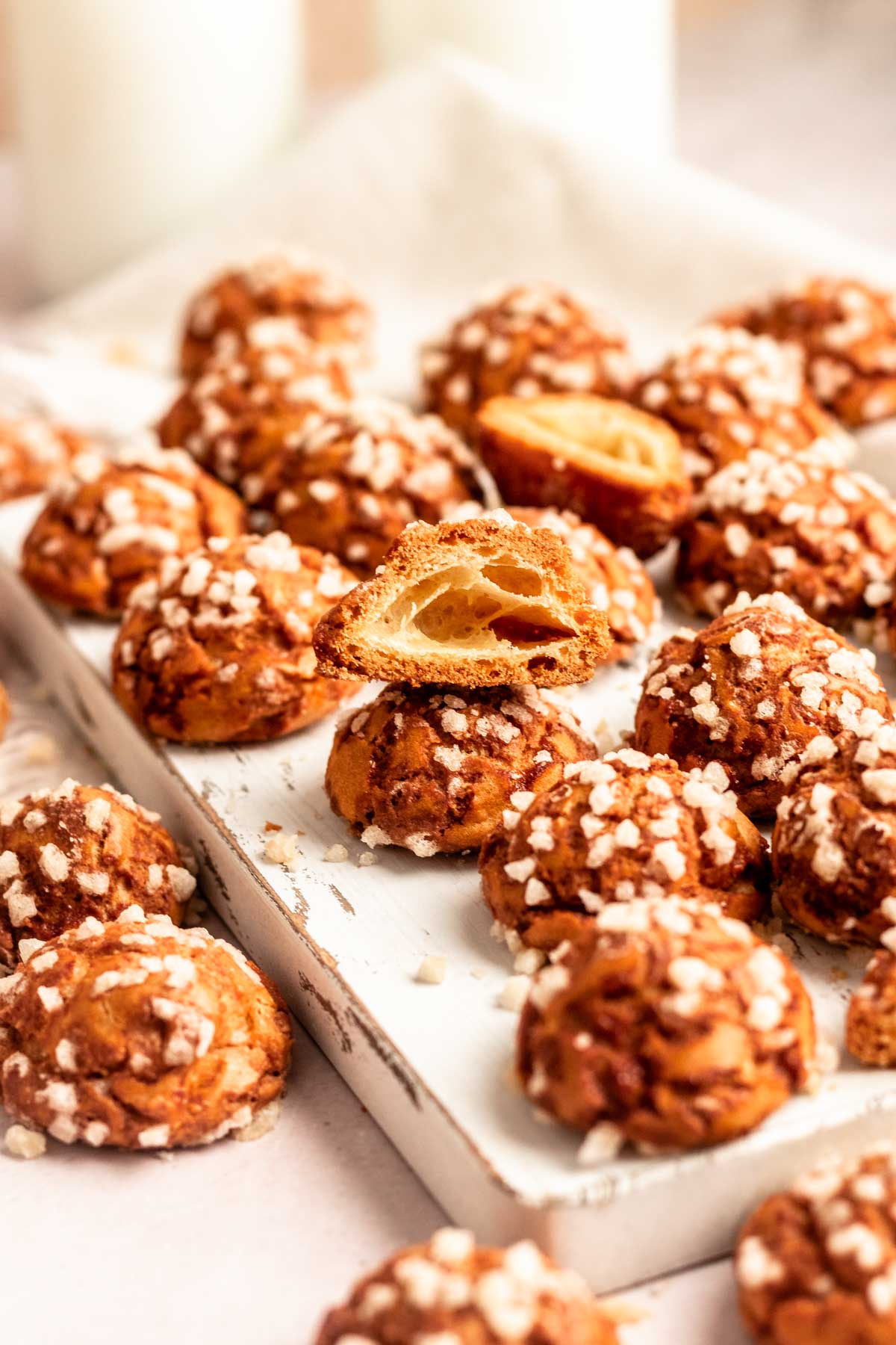 Stack of two chouquettes with the top one cut in half.