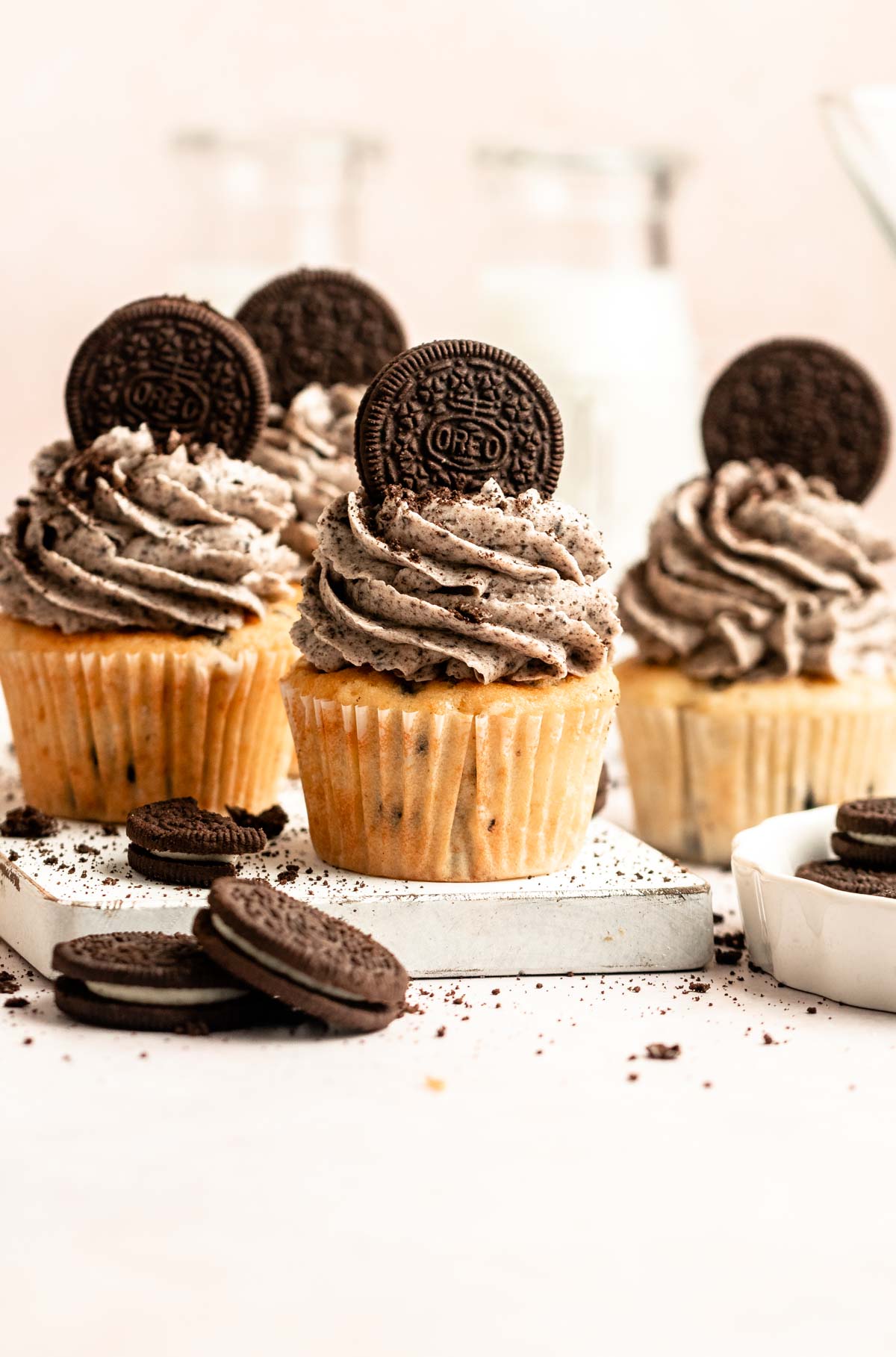 Oreo cupcakes on a white wooden board.