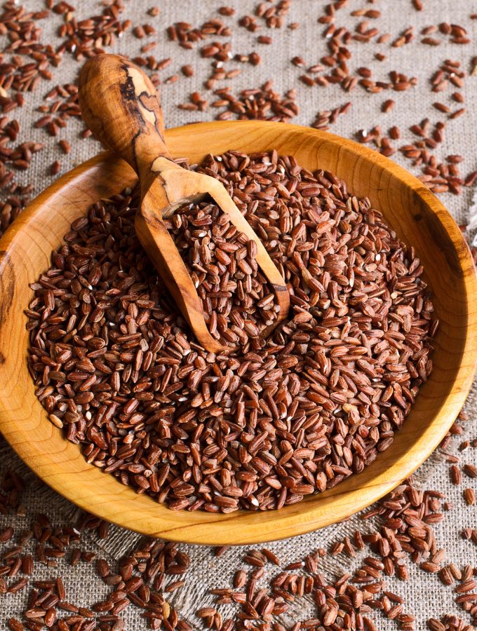 A large wooden bowl with brown rice.