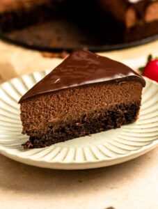 Close up of a slice of chocolate mousse cake on a plate.