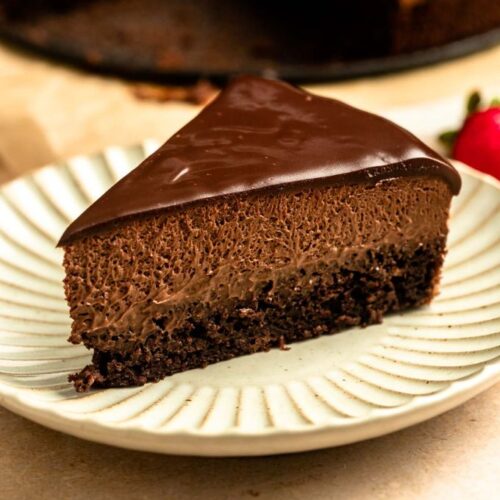 Close up of a slice of chocolate mousse cake on a plate.