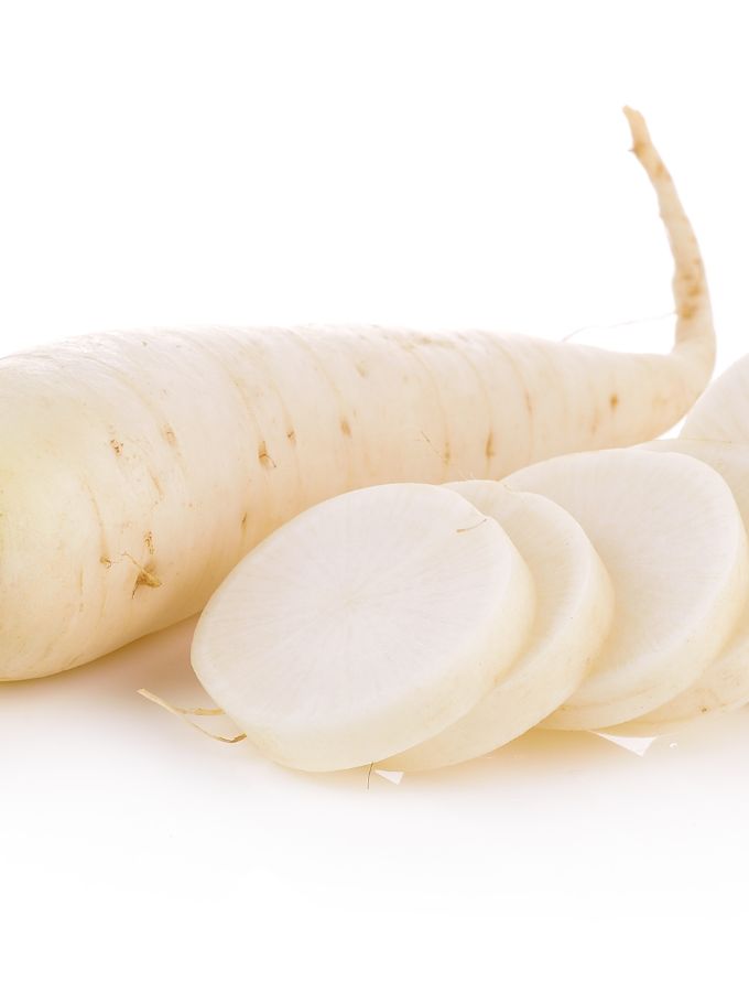 Sliced daikon radish next to a whole one.