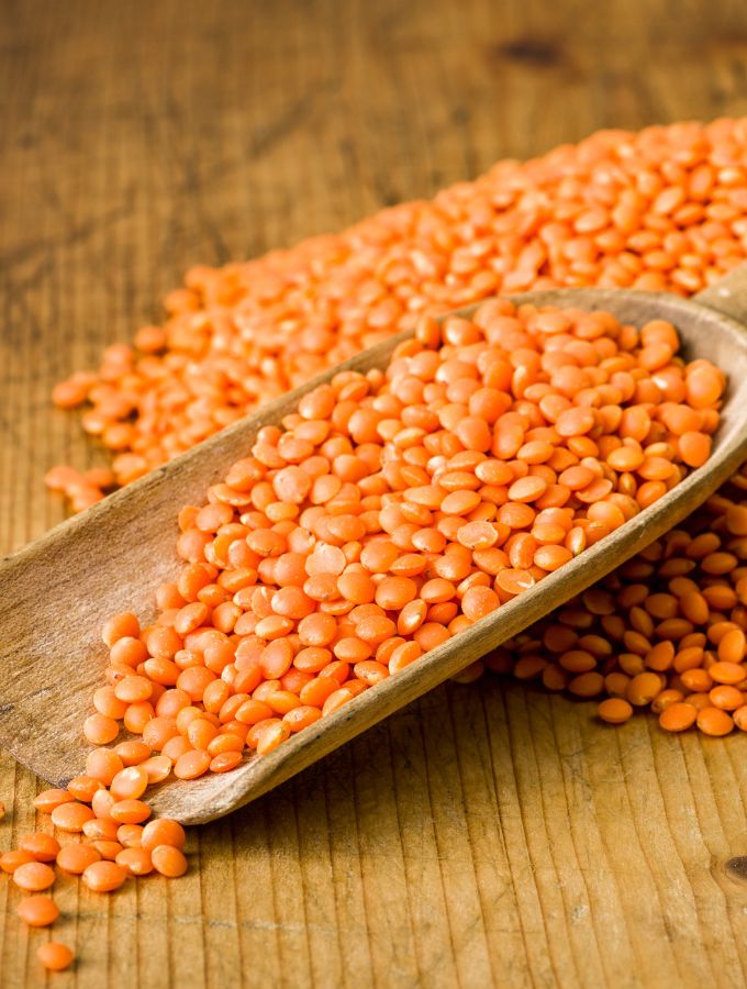 A wooden scoop with lentils.