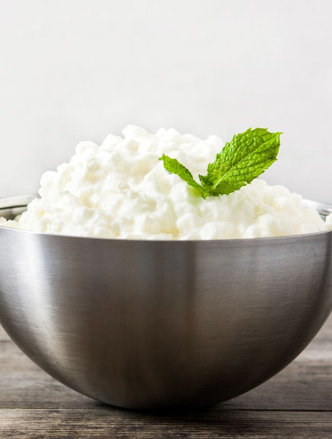 A large bowl with requeson cheese and a mint leaf.