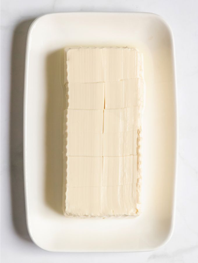 A rectangle white plate with silken tofu.