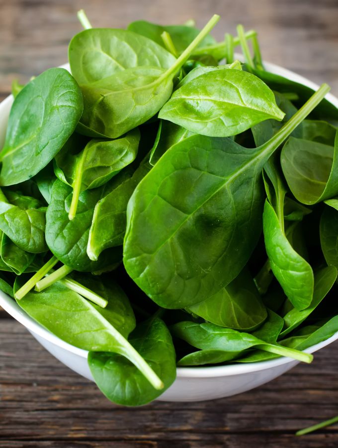 Pile of spinach in a large white bowl.