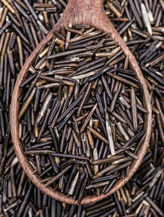 Top of a large wooden spoon with wild rice.