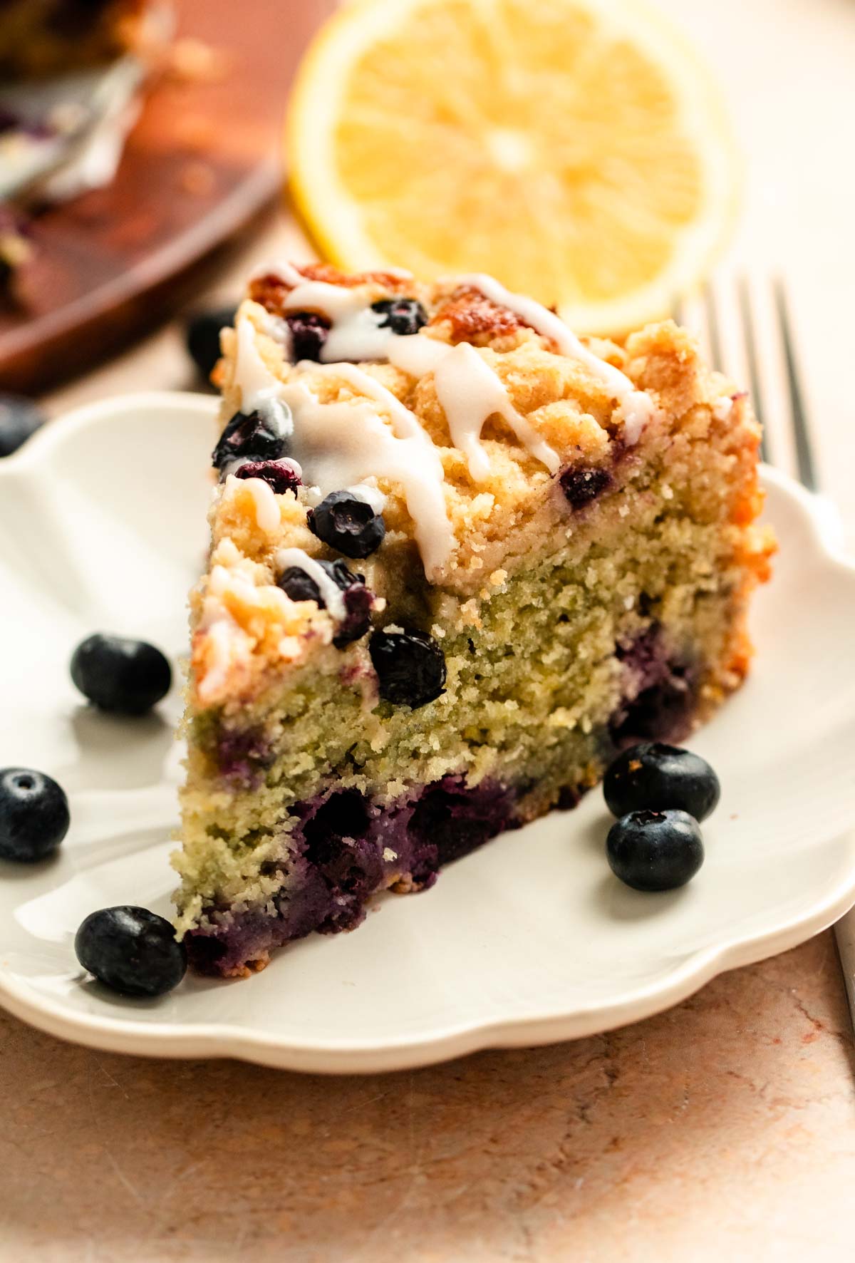 Slice of lemon blueberry coffee cake on a plate.