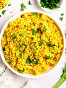 Top of a white bowl with yellow Mediterranean rice.
