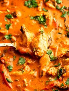Spoon holding Thai red curry chicken.