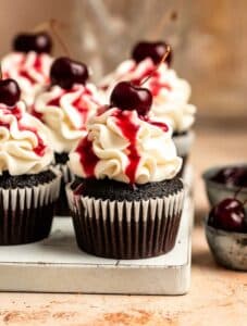 Black forest cupcakes on a white wooden board.