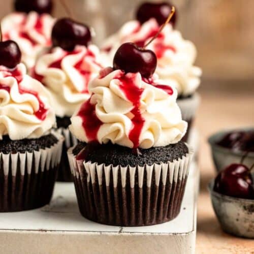 Black forest cupcakes on a white wooden board.