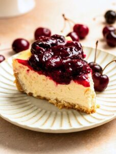 A slice of cherry cheesecake on a white plate.