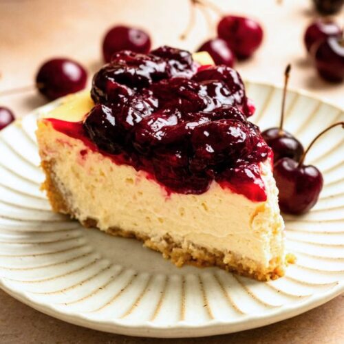 A slice of cherry cheesecake on a white plate.