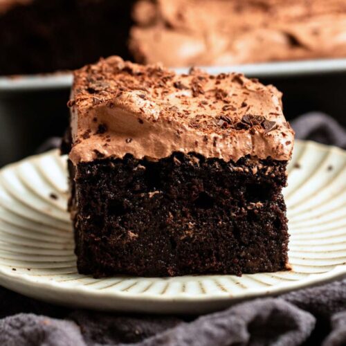 A slice of chocolate tres leches cake on a small plate.