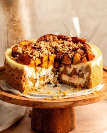 Peach cobbler cheesecake with a slice missing.
