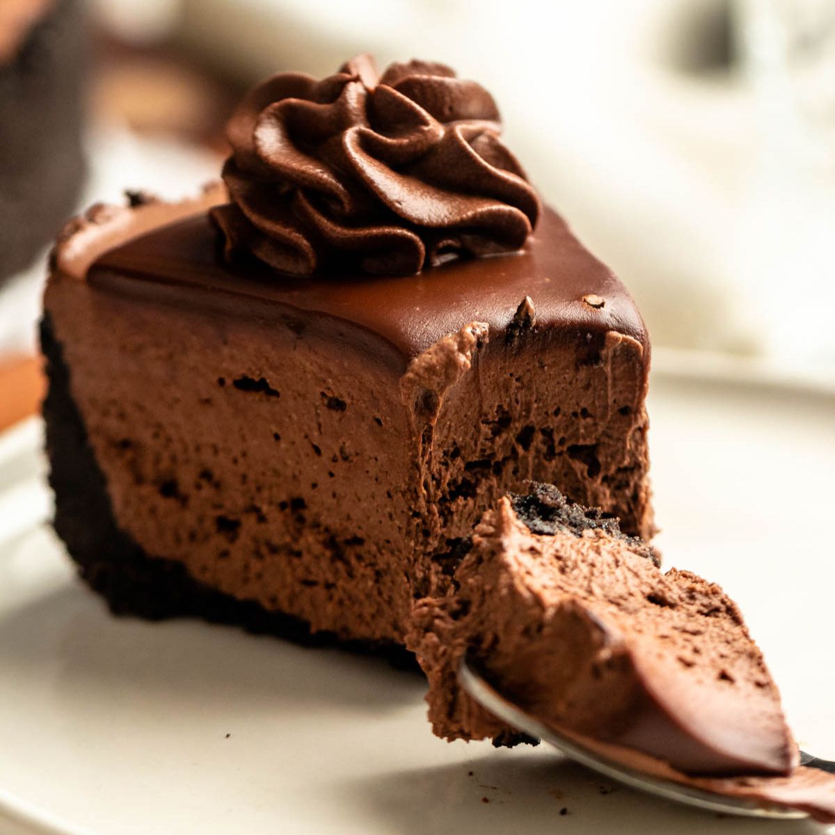 Bite missing from a slice of a no-bake chocolate cheesecake.