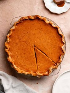 Top of a sweet potato pie with condensed milk with one slice sliced.