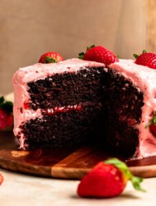 Slice missing from a chocolate strawberry cake.