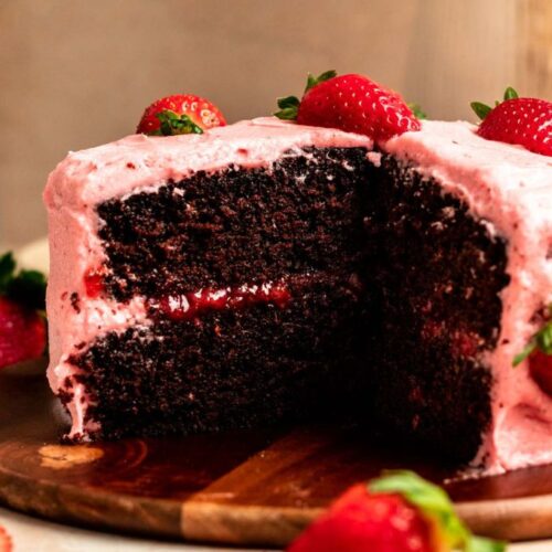 Slice missing from a chocolate strawberry cake.