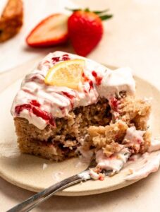 Slice of strawberry lemon cake with a bite missing.