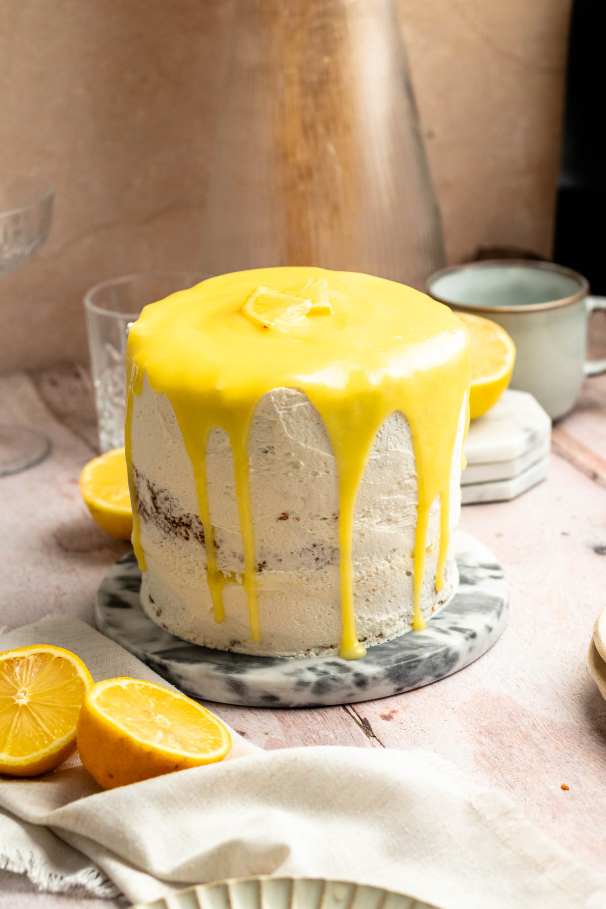 Lemon curd cake with lemon curd drip on a cake plate.