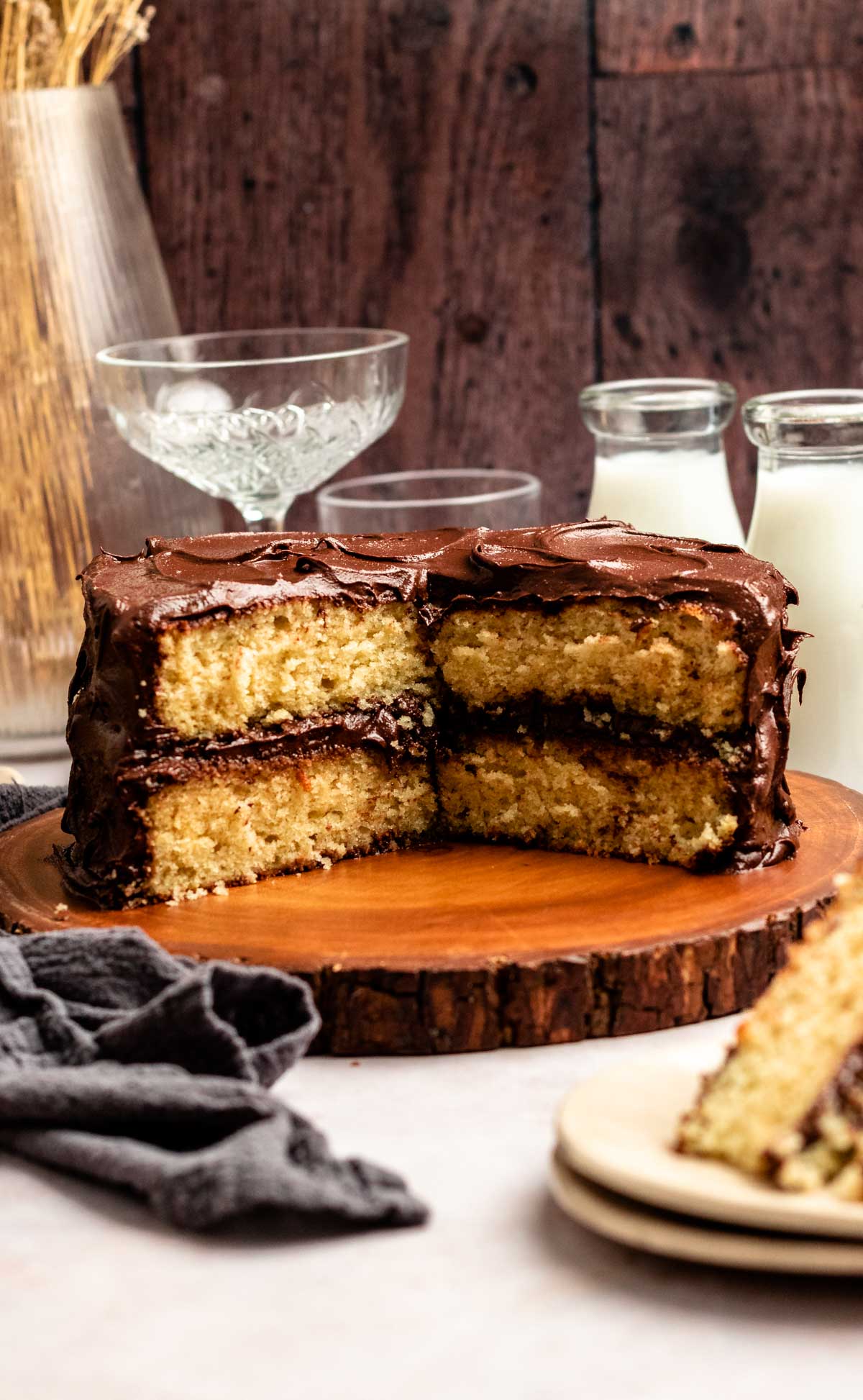 Vanilla cake with chocolate frosting with a slice missing.