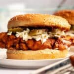 Nashville hot chicken sandwich on a white plate.