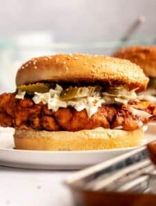 Nashville hot chicken sandwich on a white plate.