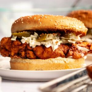 Nashville hot chicken sandwich on a white plate.