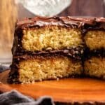 Vanilla cake with chocolate frosting with a slice missing.