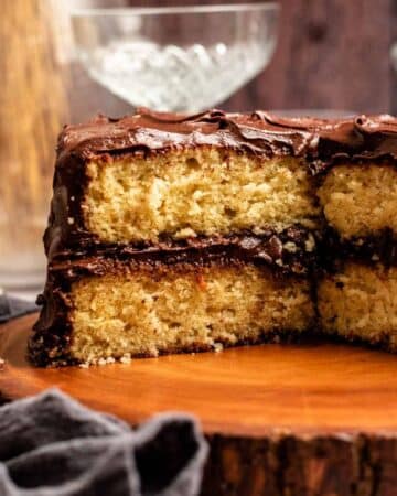Vanilla cake with chocolate frosting with a slice missing.