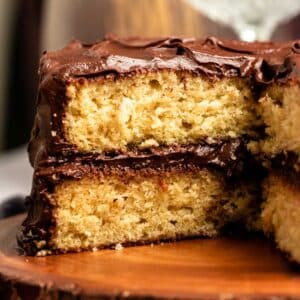 Vanilla cake with chocolate frosting with a slice missing.