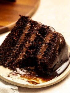 Bite missing from a slice of chocolate cake with chocolate mousse.